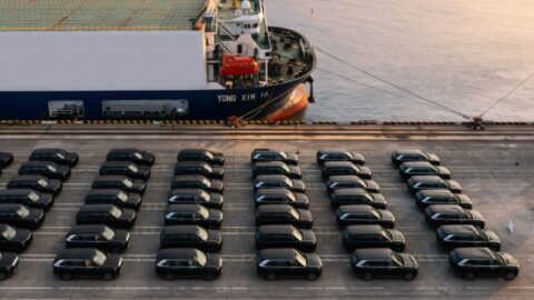 Rows of black Zeekr 9X SUVs parked beside the Yong Xin 16 vessel at a port.