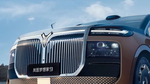 Close-up of the Voyah Dream 9's chrome grille, illuminated badge, hood ornament and split headlights.