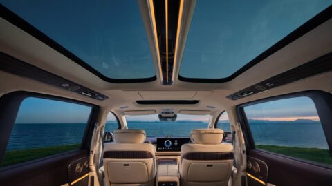 View toward the front of the Voyah Dream 9 cabin, showing its split panoramic glass roof, cream seats and ambient lighting.