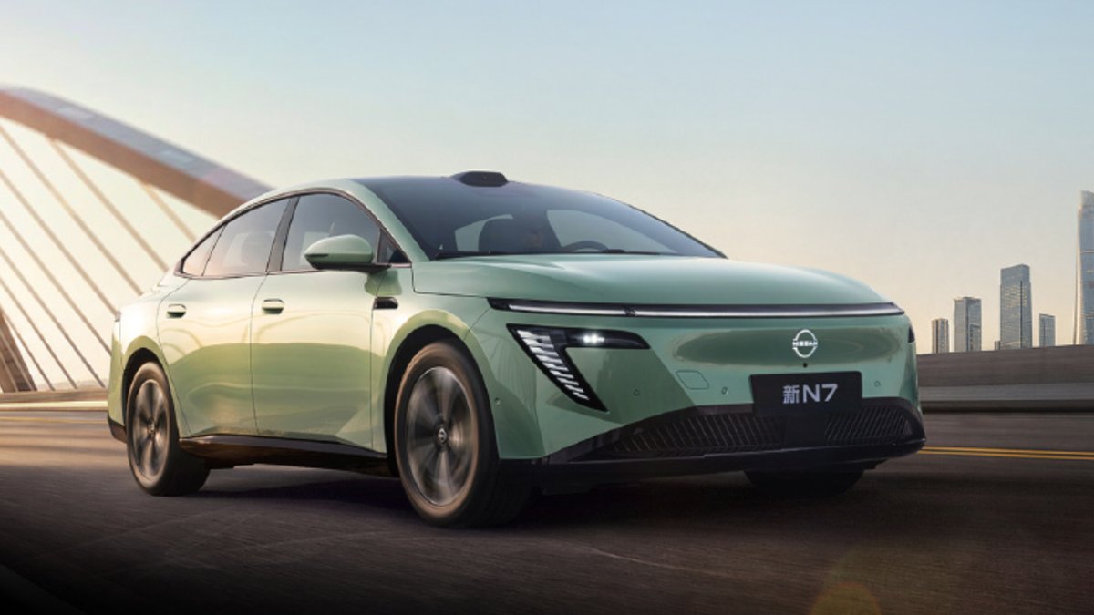 Light green updated Nissan N7 electric sedan with roof-mounted LiDAR, shown from the front three-quarter angle on a bridge.