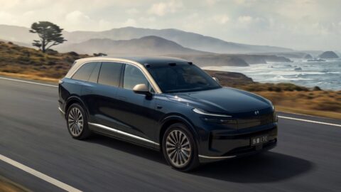 Onvo L90 with the Starry Gold 2-tone exterior driving along a coastal road.