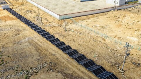 Aerial view of a long solar panel array across rocky desert terrain supplying Nio's Xingxingxia battery swap station.