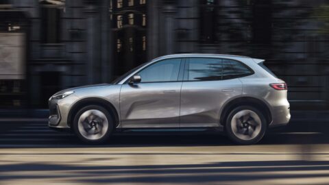 Side view of a Geely Galaxy E5 electric SUV driving along a city street.