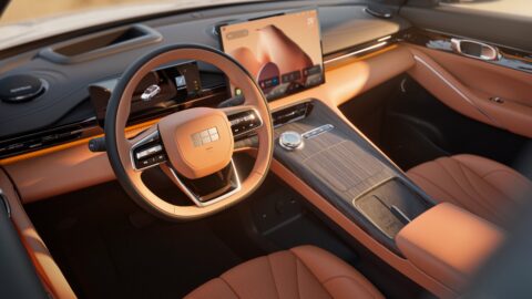 Close-up of the Geely Galaxy E5's brown interior, showing the steering wheel, digital instrument display, central touchscreen and center console.