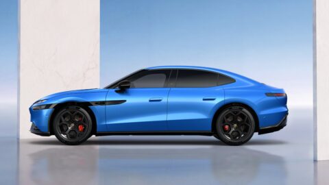 Side profile of a blue Volkswagen ID. UNYX 09, showing its fastback roofline, black wheels and red brake calipers.