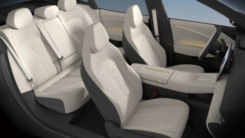 Volkswagen ID. UNYX 09 interior with light-colored front and rear seats, patterned upholstery and a center armrest.