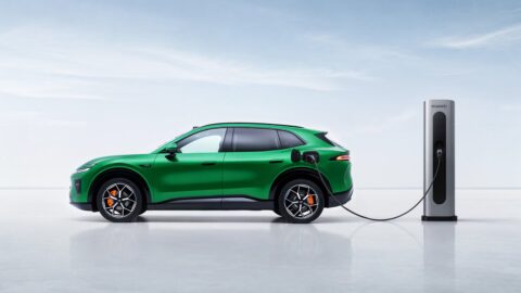 Green Changan Nevo Q06 SUV connected to a charging station, shown in side profile.