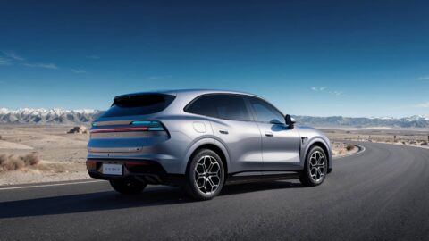 Silver Aistaland GX7 SUV shown from a rear three-quarter angle on a curving mountain road.
