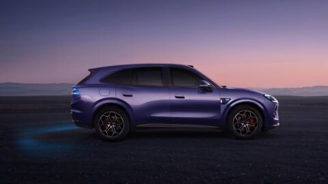 Side profile of a purple Aistaland GX7 SUV against a mountain landscape at dusk.