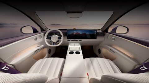 Aistaland GX7 cabin with light-colored front seats, dual dashboard screens, a center console and a panoramic glass roof.