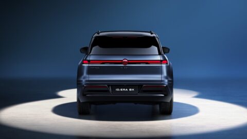 Rear view of the blue Volkswagen ID. ERA 8X, featuring a full-width red taillight bar and a centrally positioned Volkswagen badge.