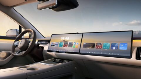 Luxeed R7 cockpit featuring a wide dual-screen display, a D-shaped steering wheel and a center console with cupholders.