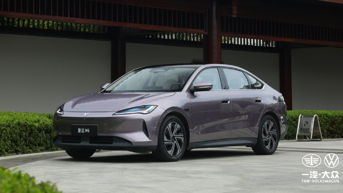 Purple Jetta M6 electric sedan viewed from the front three-quarter angle outside a traditional Chinese-style building.