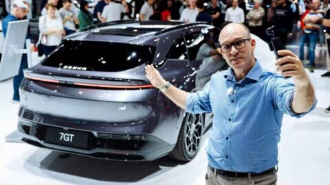 Rear view of the Zeekr 7GT at the Sydney EV show, with a visitor taking a selfie beside the car.