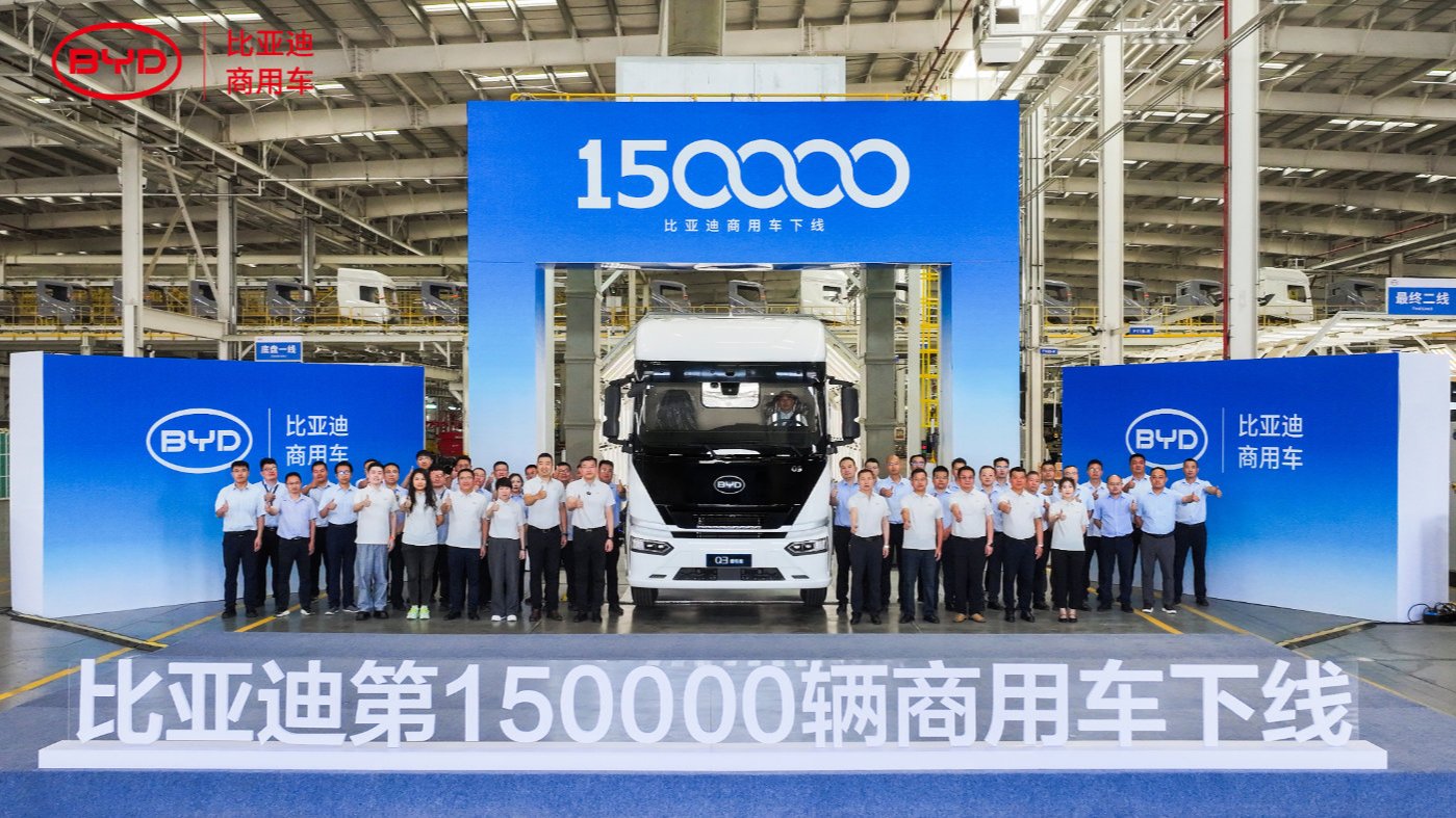 A BYD Q3 electric semi-truck surrounded by staff at a ceremony marking production of 150,000 commercial NEVs at the Huai'an plant.
