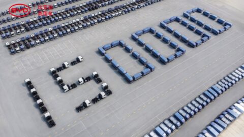 Aerial view of BYD commercial vehicles arranged to form “150000,” marking the company’s commercial NEV production milestone.