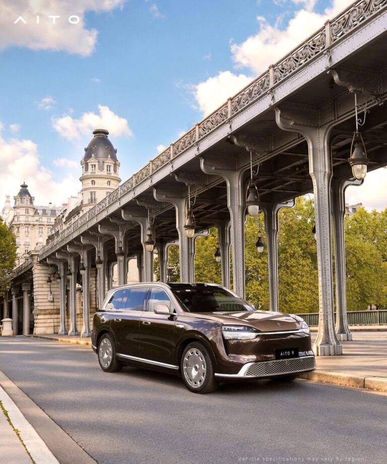 Brown Aito 9 SUV beside an elevated bridge with metal columns.