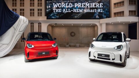 Red and white Smart #2 electric city cars displayed at the model's world premiere.