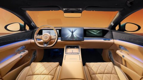 BYD Da Han EV front cabin with beige upholstery, a central touchscreen, a passenger display and blue ambient lighting.