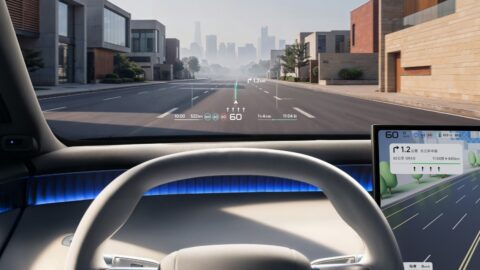 Driver's view inside the Xpeng Mona L05, showing the steering wheel, head-up display and central navigation screen.