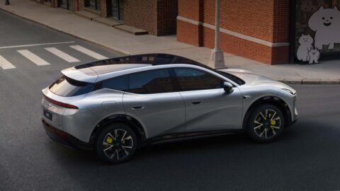 Silver Xpeng Mona L05 driving along an urban street, viewed from a rear three-quarter angle.
