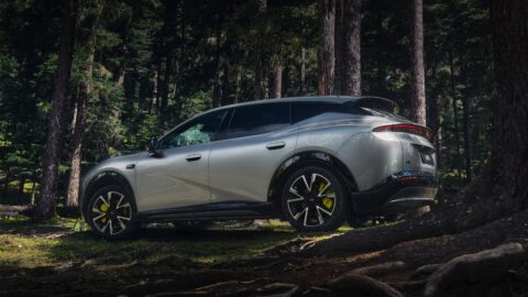 Silver Xpeng Mona L05 parked among trees, viewed from a rear three-quarter angle.