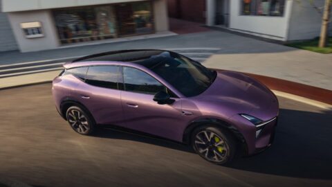 Purple Xpeng Mona L05 driving along a street, viewed from an elevated front three-quarter angle.