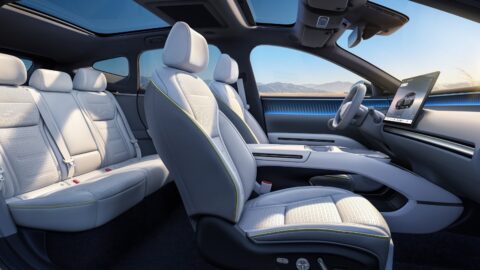 Xpeng Mona L05 cabin with light-colored seats, a panoramic glass roof and a central touchscreen.