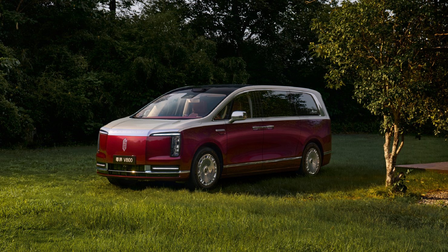 A red and silver Maextro V800 luxury MPV parked on grass, viewed from the front and side.