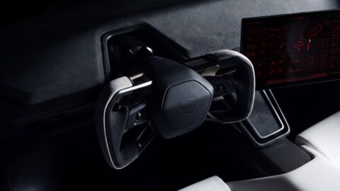 Close-up of the Tesla Roadster's steering yoke beside the center touchscreen.