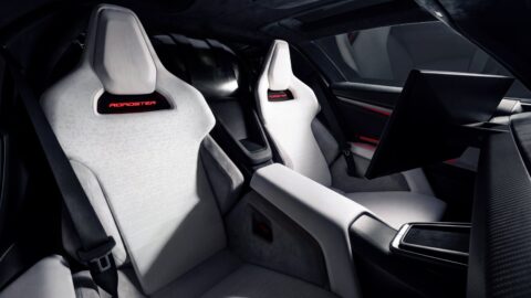 Tesla Roadster's white bucket seats with integrated headrests and red Roadster lettering.