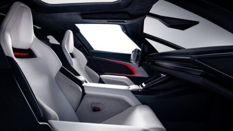 Side view into the Tesla Roadster cabin, showing sculpted white seats, a center console and touchscreen.