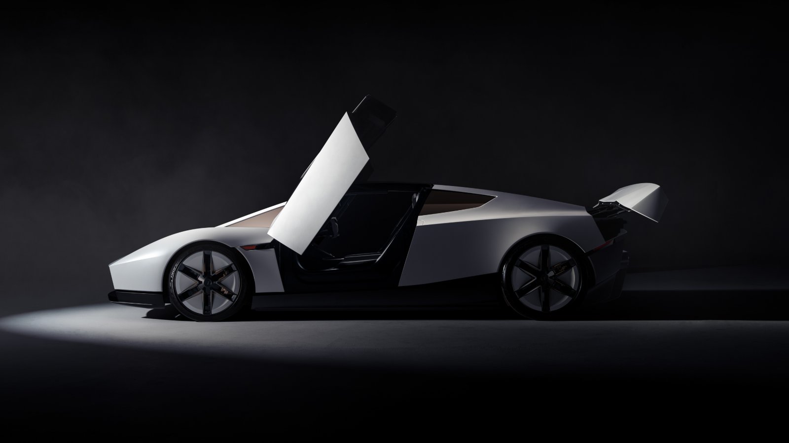 Side view of the redesigned Tesla Roadster with an upward-opening door and raised rear wing.
