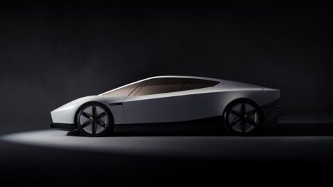 Side profile of the Tesla Roadster, showing its low body and gold-tinted windows.