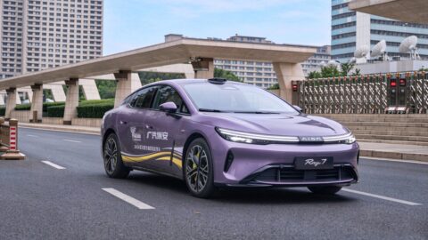 Purple GAC Aion Ray 7 driving along an urban road, viewed from the front and side.