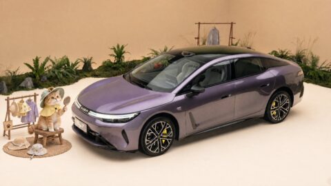 Purple GAC Aion Ray 7 displayed beside plants and decorative figures in a warmly lit indoor setting.
