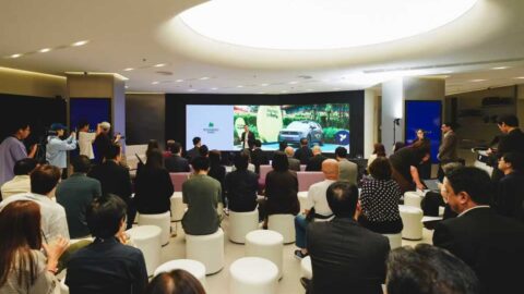 Guests seated in a Firefly showroom watch a presentation on a large screen.