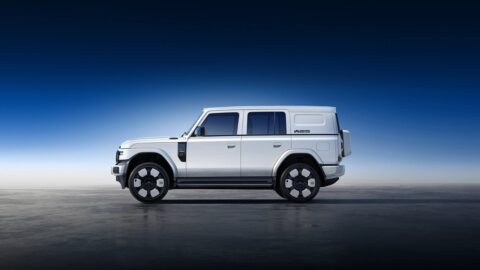 Side profile of a white iCar V25 showing its boxy body, black wheel arches and side step.