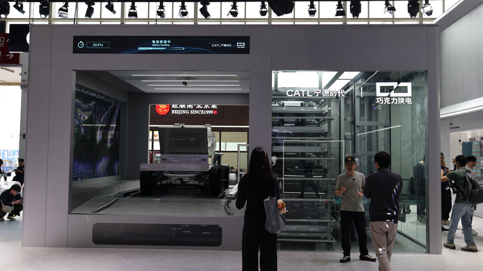 CATL Choco battery swap station with an exposed vehicle chassis and battery storage racks on display.